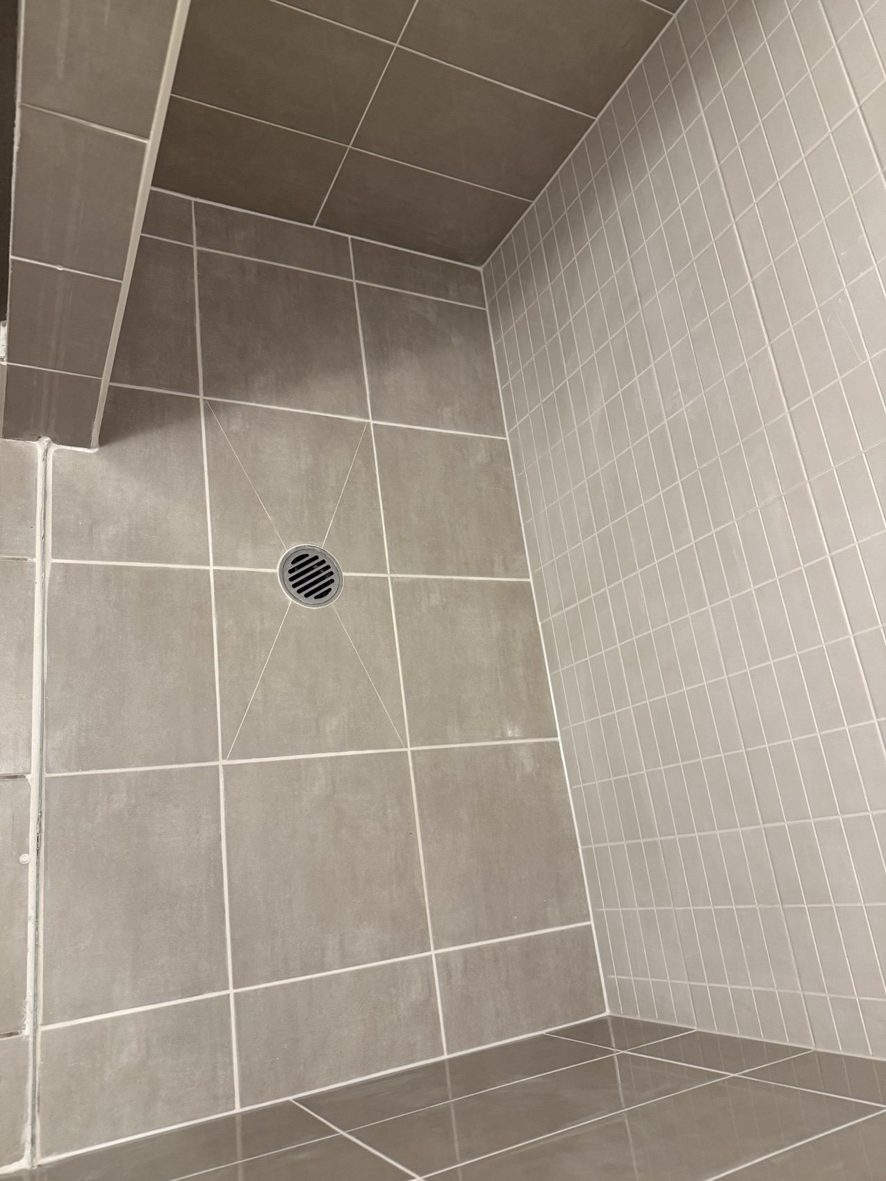 Tiled shower floor and wall junctions with clean grout and sealant lines