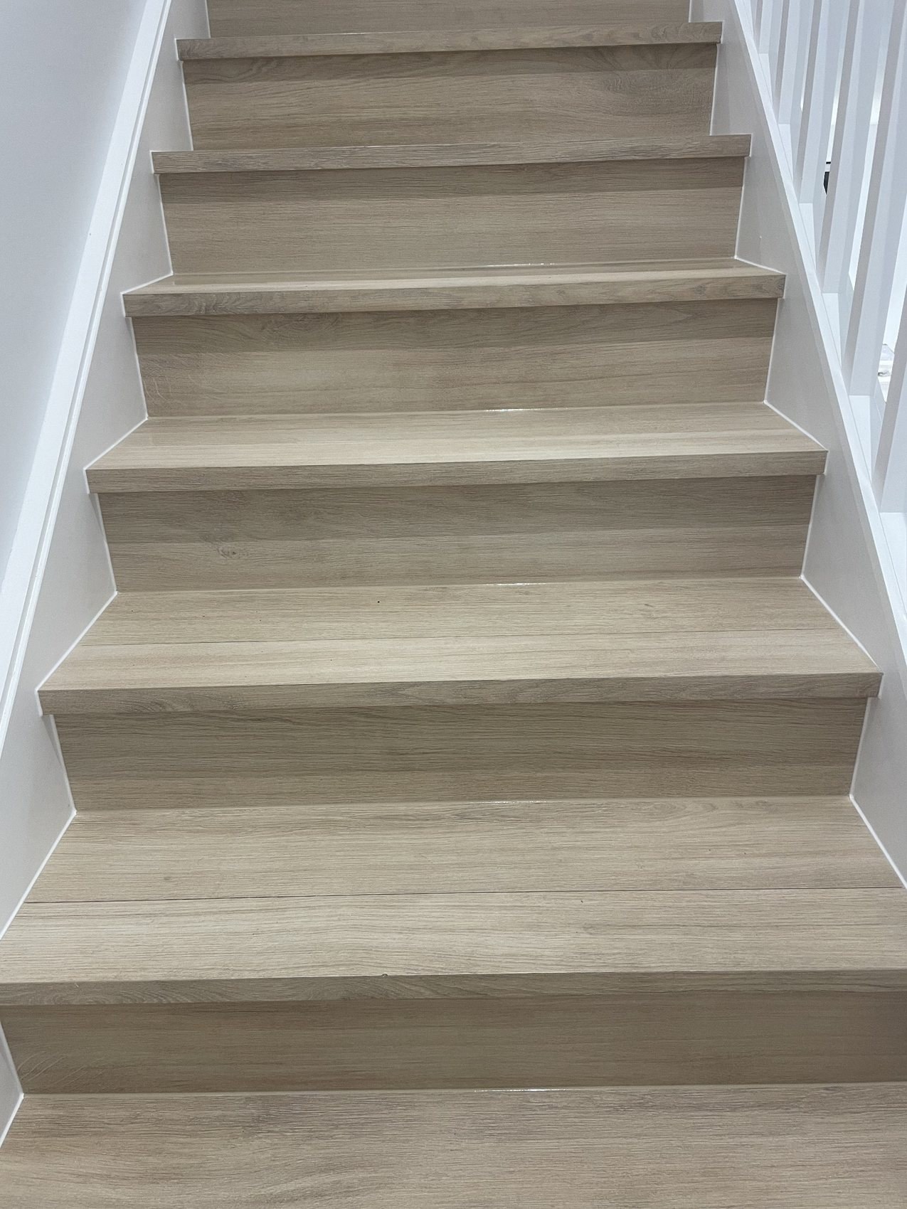 Timber staircase with white skirting and neat caulking at wall edges